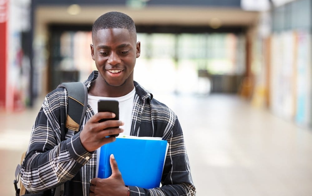 Young man uses a prepaid cell phone in college